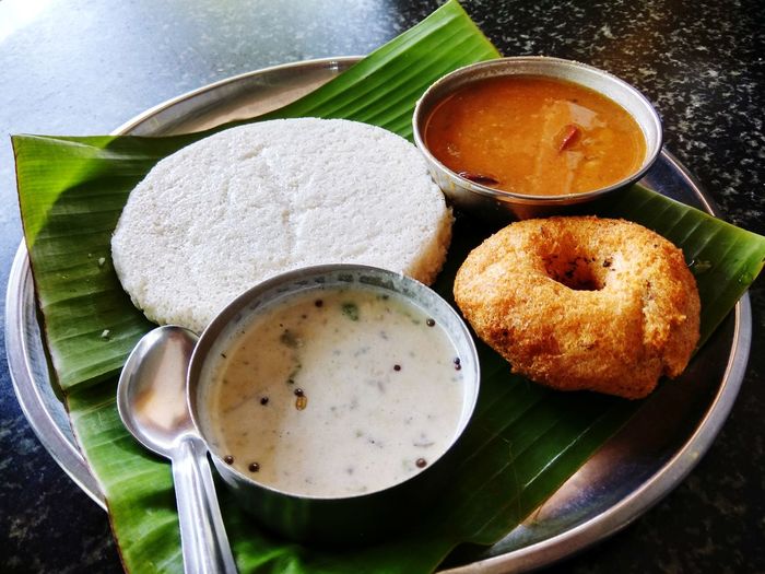 Close-up of idli and medu vada served in plate on table