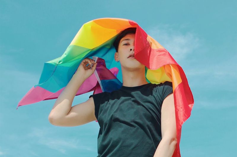 Low angle view of man with rainbow flag
