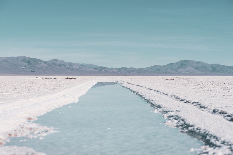Scenic view of salt flat against sky