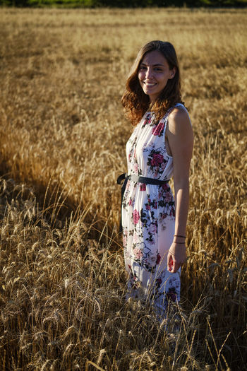 Portrait of smiling woman standing on field