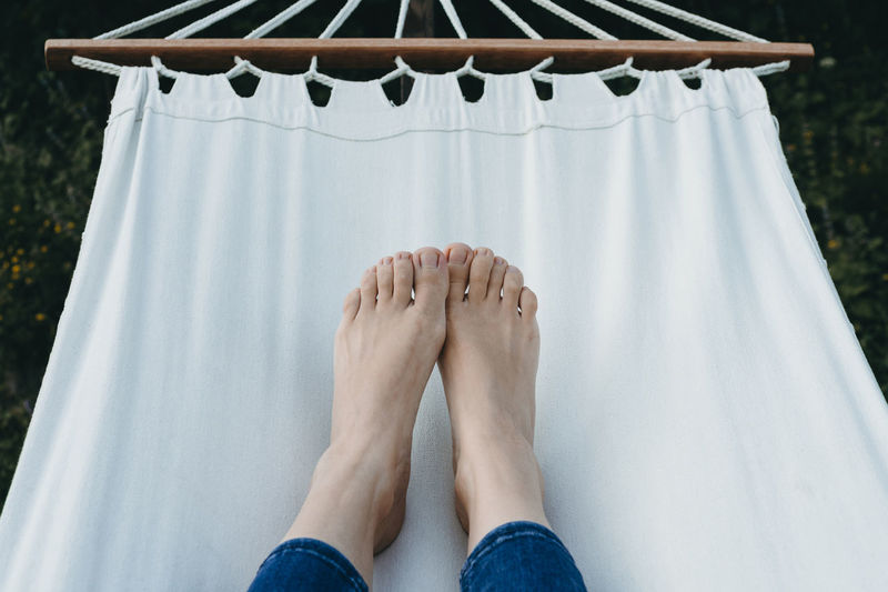 Low section of woman lying on hammock