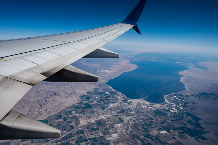 Aircraft wing against clear blue sky