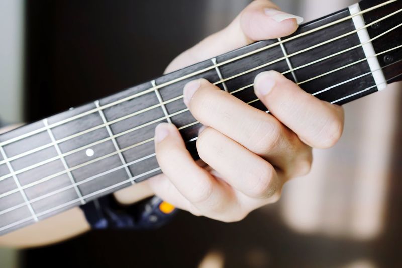 Cropped hand playing guitar