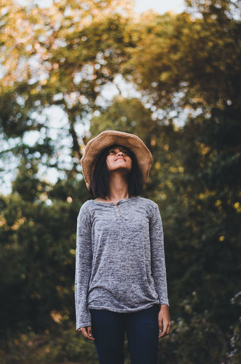 Young woman looking away while standing outside