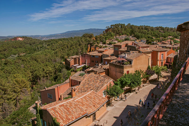 Panoramic view of forests over hills and houses roofs from roussillon, in the french provence.