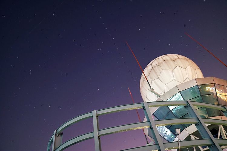 Low angle view of observatory against star field in sky at night