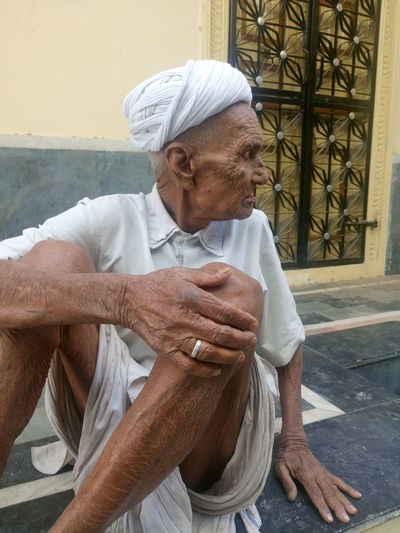 Senior man sitting outside house