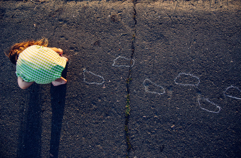 Girl drawing on asphalt