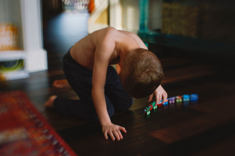 Shirtless boy playing with toy train