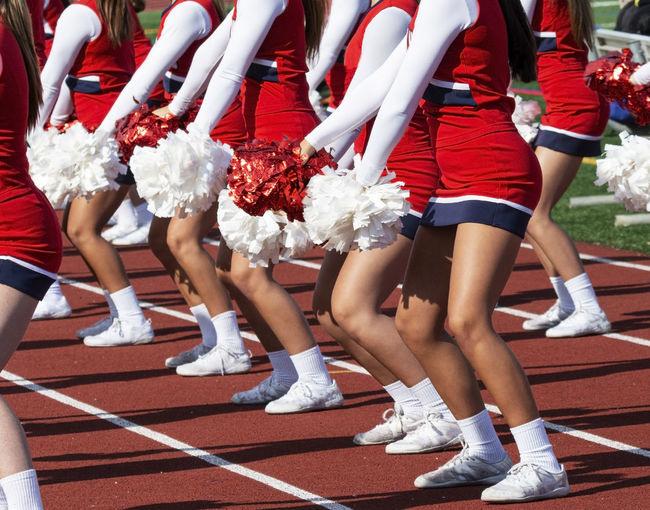 Low section of cheerleaders dancing during sports event