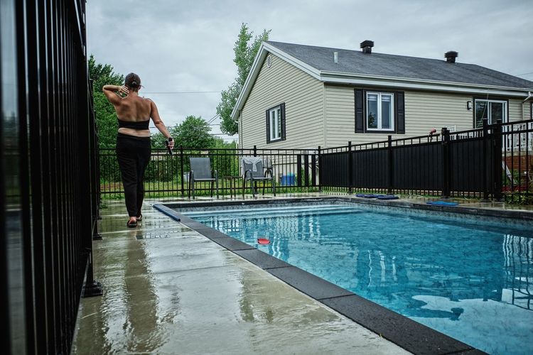Rear view of man standing by swimming pool
