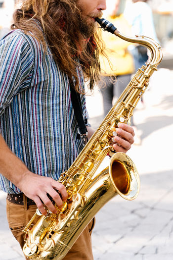Portrait of a young man playing saxophone in the street