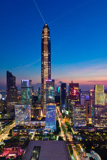 Illuminated buildings in city against sky at night