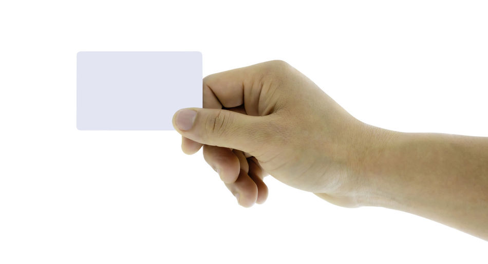 Close-up of hand holding paper against white background