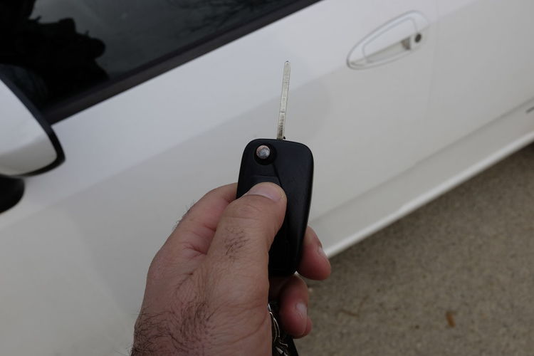Close-up of man holding car key