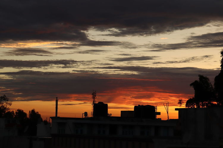 Silhouette buildings against sky during sunset
