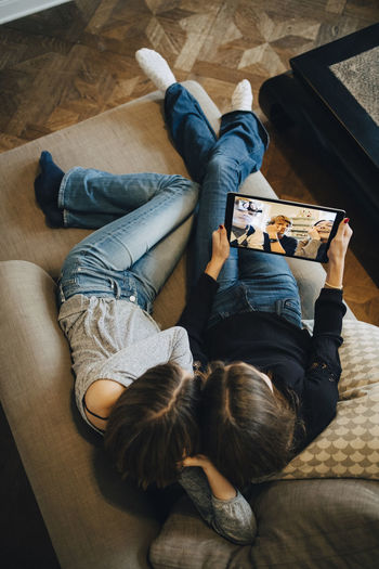 HIGH ANGLE VIEW OF PEOPLE LYING ON FLOOR AT HOME