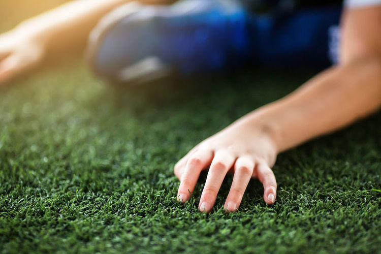 Close-up of hands on grass