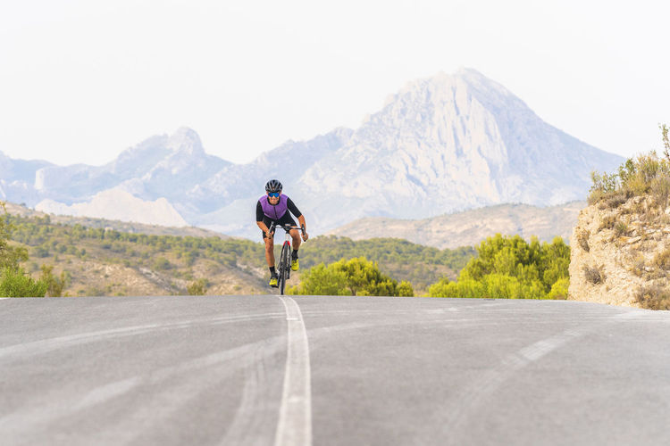 Male sportsperson riding bicycle on mountain road