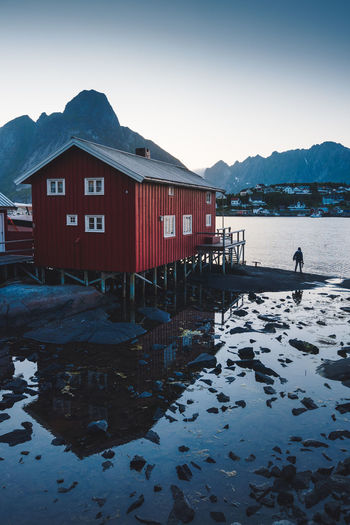 House by lake against sky during winter