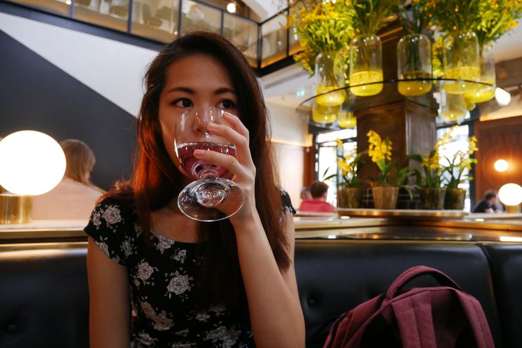 Portrait of woman drinking glass in restaurant