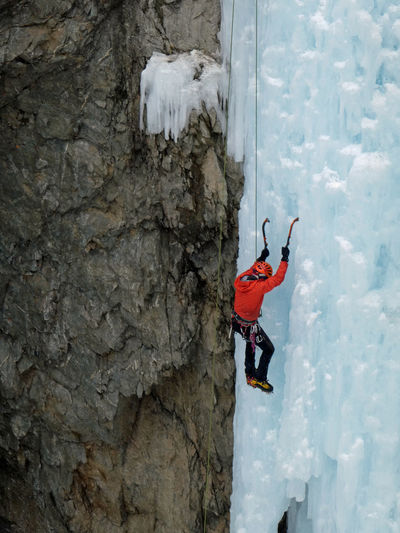 Man climbing on snow covered mountain