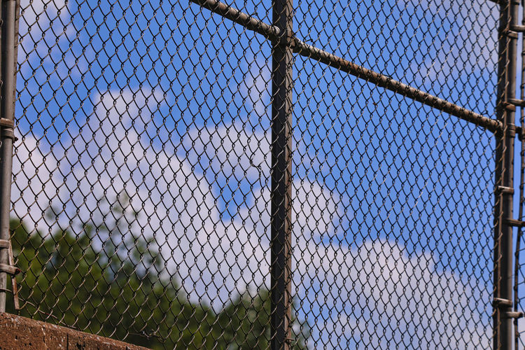 Full frame shot of chain link fence against blue sky