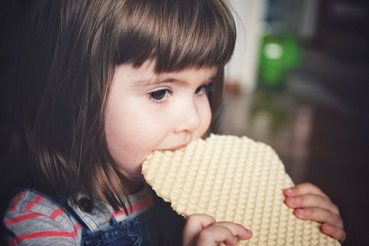 Close-up of girl eating waffle