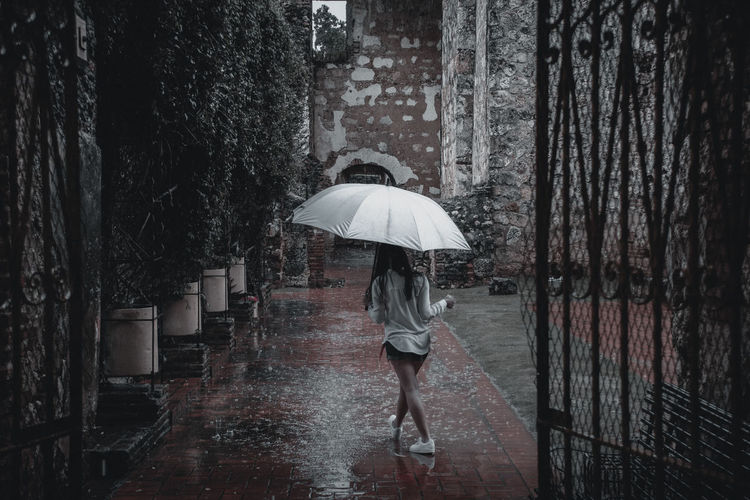 Woman walking on wet umbrella during monsoon
