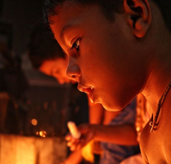 Little boy portrait infront of burning candle