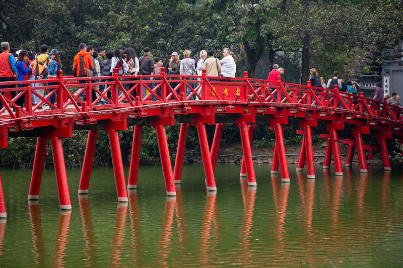 Group of people on bridge against trees