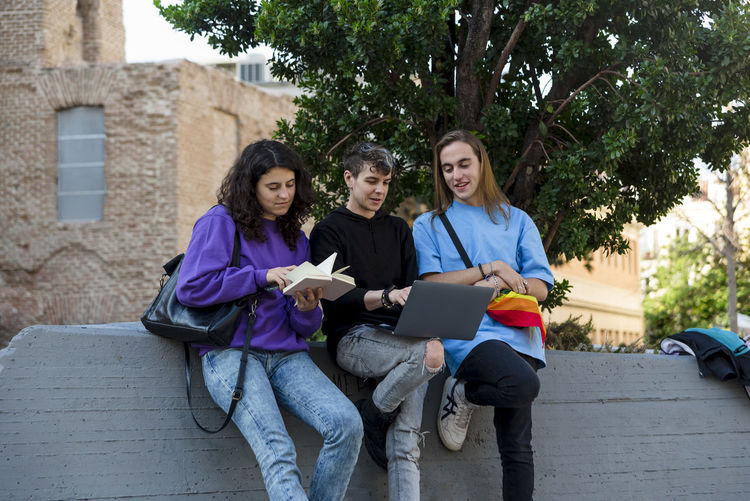 Portrait of smiling friends using digital tablet