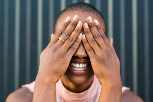 Close-up of laughing woman covering face