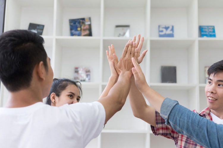 Colleagues giving high five at office
