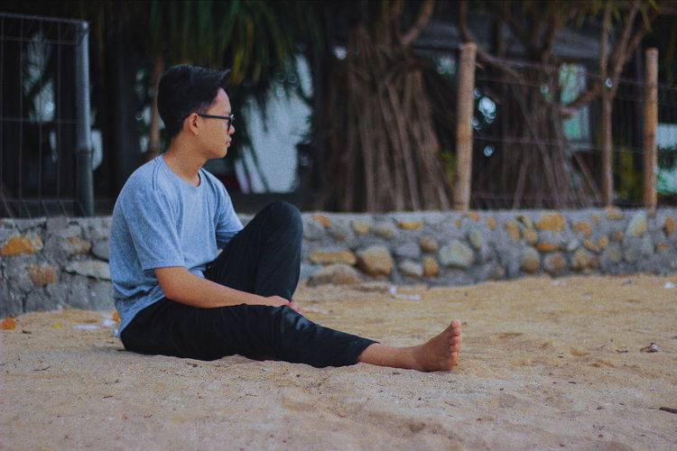 Man sitting on sand at beach