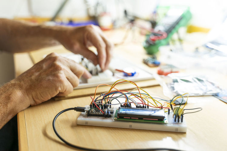 Senior man working on electronic circuits in his workshop