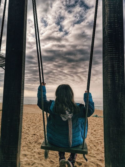 Rear view of woman on swing in playground