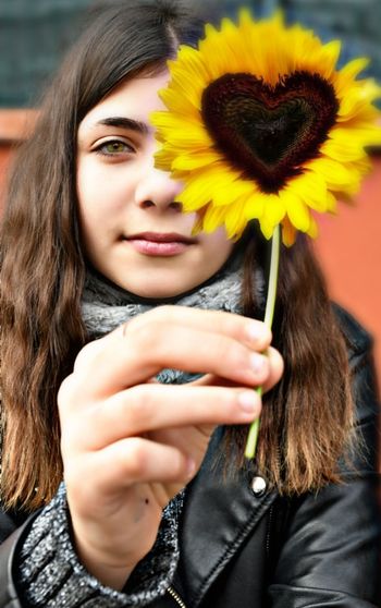 Portrait of beautiful woman holding yellow flower