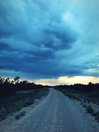 Road amidst landscape against dramatic sky