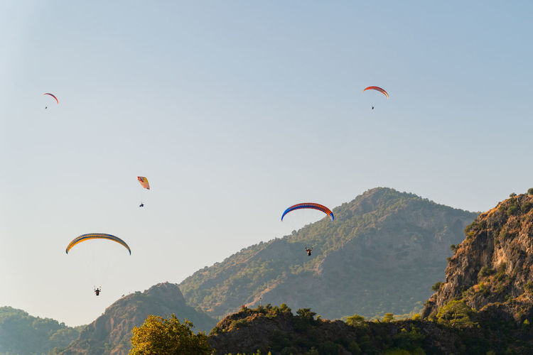 Fly away - paragliders soar and descend in a valley near fethiye in turkey.