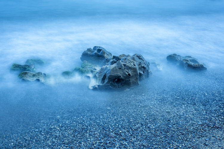 Scenic view of sea and rocks with silk effect