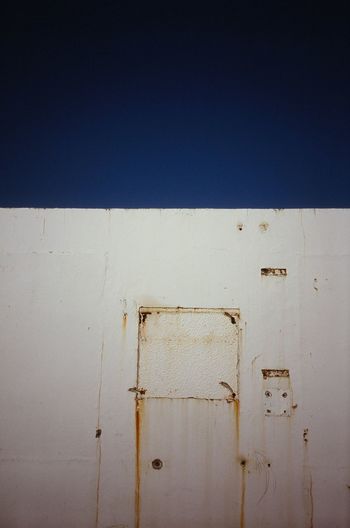 Close-up of wall against clear blue sky