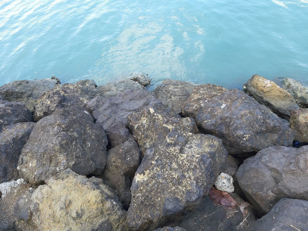 HIGH ANGLE VIEW OF ROCKS IN SEA