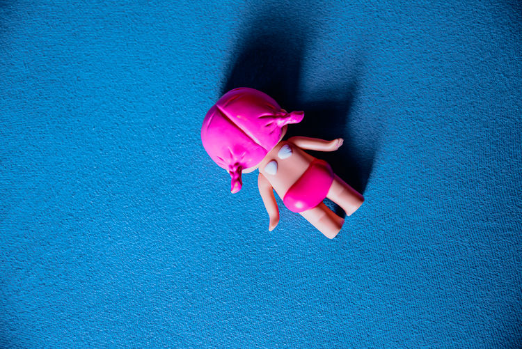 High angle view of pink balloons against blue wall
