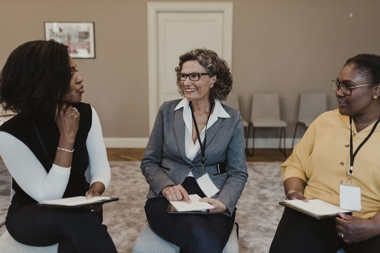 Multi-ethnic female colleagues discussing in meeting at education class