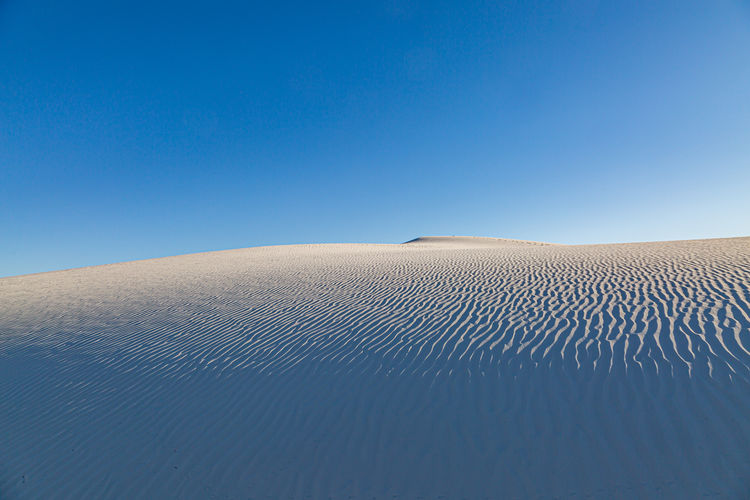 Rippled sand dunes at white sands national monument in new mexico, with a blue sky overhead