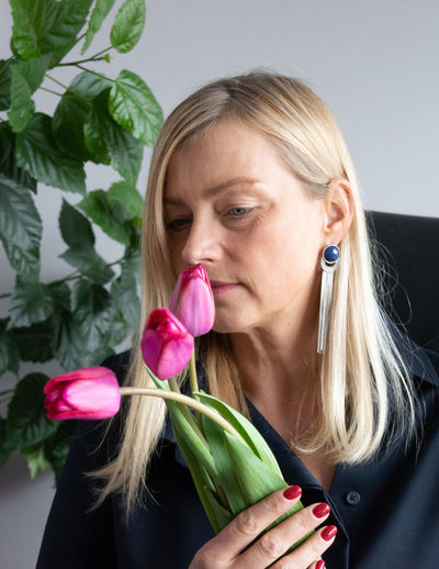 Close-up of woman smelling flower at home