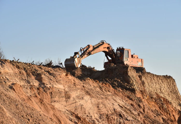 Large excavator working at construction site. backhoe during earthworks on sand quarry.