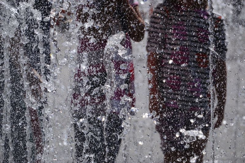 Close-up of kids in fountain water in city