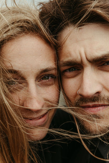 Up close of man and woman with eyes next to each other and windy hair
